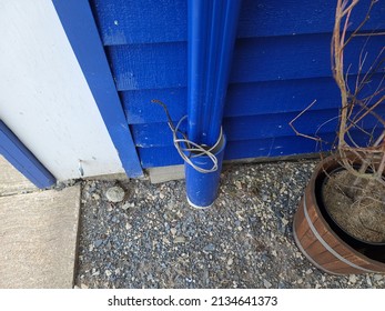 Loose Wires Wrapped Around A Blue Drain Pipe.