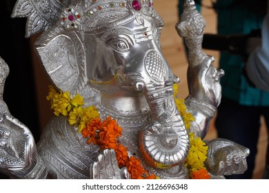 Lord Ganesha, Close up of Sculpture , Silver figure decorated with flowers, Indian Elephants. Large Silver metal statue of God hinduism of elephant or Ganesha sitting on the base in the shrine.