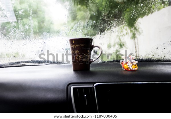 lord ganesha and\
coffee mug on car dashboard\
