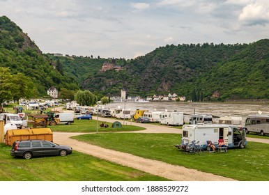 Loreley, Germany - May 24, 2019: Caravans and recreational vehicles camp on the banks of the Rhine River in the Rhine River Gorge opposite the historical Loreley Statue.