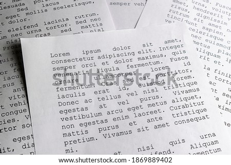 lorem ipsum dolor sit amet concept. selective focus photo of paper sheets with publishing and graphic design placeholder text on them.