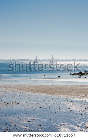     Lorient, Larmor Plage, beach, low tide with sailing boats in sunlight 