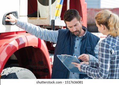 Lorry Driver Taking Instructions From Female Colleague With Clipboard