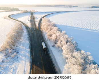 Lorry truck on the road surrounded by winter forest. Aerial view