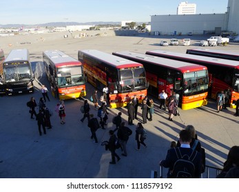 LOS ANGELES, CALIFORNIA—JANUARY 2018: Close Up Of Passengers From A Charter Flight Board Tour Buses At The Los Angeles International Airport Runway Early In The Morning.