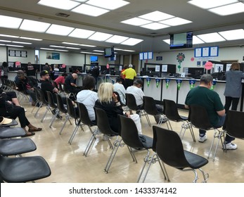 LOS ANGELES, April 25, 2019: DMV Department of Motor Vehicles Culver City. Long rows of chairs with people sitting, waiting their turn, inside the busy waiting room area.