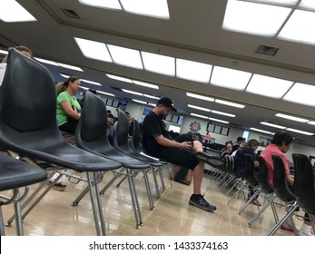 LOS ANGELES, April 25, 2019: DMV Department Of Motor Vehicles Culver City Interior. Slanted View Of A Caucasian Man Sitting On A Chair Inside The Waiting Room Area At The DMV.