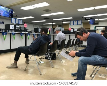 LOS ANGELES, April 25, 2019: DMV Department of Motor Vehicles Culver City. People on chairs sitting near the counters inside the waiting room area.