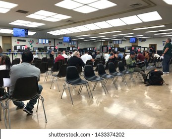 LOS ANGELES, April 25, 2019: DMV Department Of Motor Vehicles Culver City. Long Rows Of Chairs With People Sitting, Waiting Their Turn, Inside The Busy Waiting Room Area.