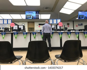 LOS ANGELES, April 25, 2019: DMV Department of Motor Vehicles Culver City interior. A Caucasian man is standing in front of empty chairs at the counter at the DMV field office.