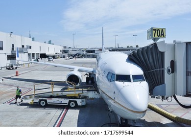 LOS ANGELES, CA -26 APR 2020- An Airplane From United Airlines (UA) And A Baggage Handler Wearing A Face Mask During The COVID-19 Crisis At The Los Angeles International Airport (LAX).