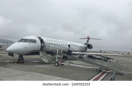 LOS ANGELES, CA, APR 2016: US Airways Express Jet Parked At Long Beach Airport On An Overcast Day. Passenger Walks Up Entry Ramp