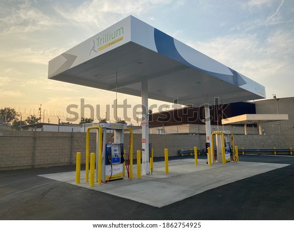 LOS ANGELES, CA, AUG\
2020: wide angle view of filling station for vehicles powered by\
natural gas in the China Town area of Downtown, golden sunset light\
in background