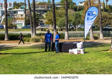 Los Angeles, CA -  CIRCA 2018: Two United Way Charity Volunteer Help Workers Having A Discussion Near A Sign Up Table