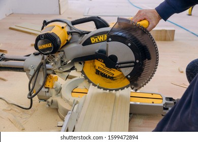 Los Angeles CA DEC 20 2019: Power Miter Saw DeWalt On A Cut Wooden Trim Base Molding For New House Under Construction