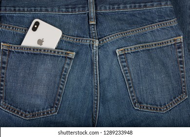 Los Angeles, CA - January 19, 2019: Close Up Of Back Side Of Mens Jeans With Silver IPhone X Sticking Out From The Left Pocket. Back Part Of The Phone Showing The Dual-lens And Apple Logo. 