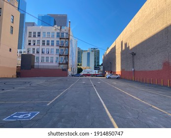 LOS ANGELES, CA, NOV 2020: Mostly Empty Parking Lot In Downtown With LA Metro Red Bus Passing In Front Of A Hispanic Wedding Chapel At The Far End, Skyscrapers Visible Over Near Buildings