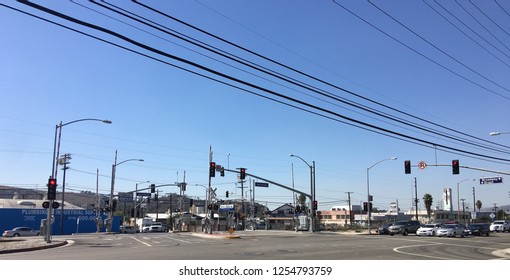 LOS ANGELES, CA, OCT 2016: Industrial Park Area With Railway And Road Crossing In Glendale Area. Power Cables Overhead And Various Vehicles Waiting At Stop Lights