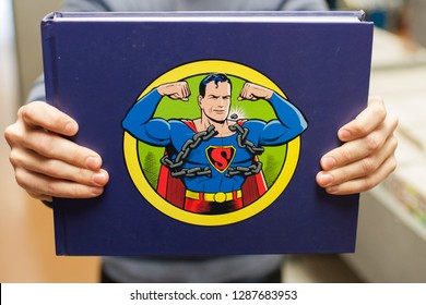 Los Angeles, CA - September 3, 2012: Teenage Boy Holding Up A Superman Comic Book At The Comic Book Store. 