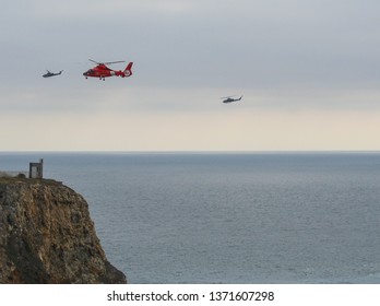 Los Angeles, CA / USA - February 14, 2006: A Bright Red US Coast Guard Dolphin Helicopter Conducts Training Rescue Operations Off Point Vicente California, Rescuing A Man Off The Cliff.