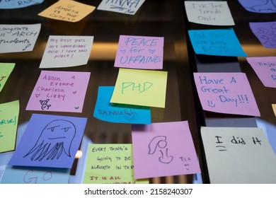 Los Angeles, CA, USA - May 11, 2022: A  note that says PHD is seen among other notes with various messages on a storefront window at the University of Southern California campus before graduation day.