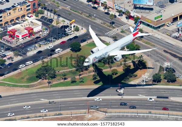 Los Angeles, CA / USA - September13 2019: Aerial\
view of American Airlines Boeing 787 Dreamliner landing at KLAX\
airport. Widebody aircraft on final approach over a park and roads.\
Air to air photo.