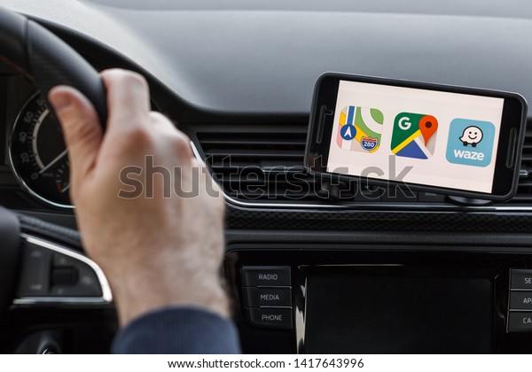 LOS ANGELES,\
CALIFORNIA - JUNE 6, 2019: Close up to male driving and using\
different navigation application Google maps, Apple Maps, Waze. An\
illustrative editorial\
image