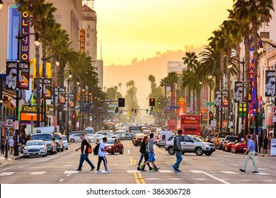 LOS ANGELES, CALIFORNIA - MARCH 1, 2016: Traffic and pedestrians on Hollywood Boulevard at dusk. The theater district is famous tourist attraction.