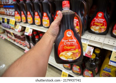 Los Angeles, California, United States - 05-20-2022: A View Of A Hand Holding A Bottle Of Pearl Milling Company Syrup, On Display At A Local Grocery Store.