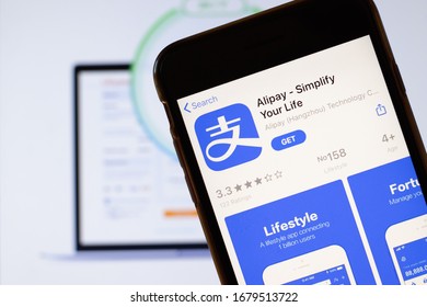 Los Angeles, California, USA - 24 March 2020: Alipay app logo on phone screen close up with website on background with icon, Illustrative Editorial