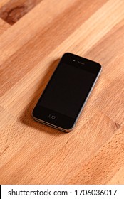 Los Angeles, California / USA - April 9 2020: Black/blank IPhone 4 On A Wooden Desk Top