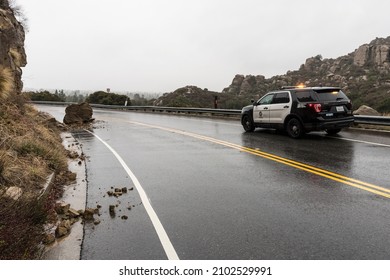 Los Angeles, California, USA - December 30, 2021:  Los Angeles Police Car Observing Small Rain Soaked Landslide On Santa Susana Pass Road.