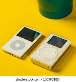 Los Angeles, California / USA - Feb 27 2019: Styled Minimalistic Photo Of The First Generation IPod And The 5th Generation IPod On A Yellow Background