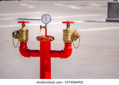 Los Angeles, California USA - Feb 6, 2020: Close Up View Of A Tall, Red Standpipe In An Empty Parking Lot.  There Is A Pressure Gauge In The Center Along With Two Brass Valves On Both Sides.