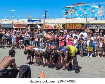 Los Angeles, California, USA- July 26 2011: A Man Doing A Street Show Jumping Over People Watched By The Crowd At The Boardwalk In Venice Beach, Los Angeles, California, USA.