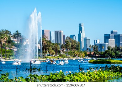 Los Angeles, California / USA - June 23 2018: Tourists ride in the new swan shaped pedal boats around the fountain of water at Echo Park Lake. The lake has a beautiful view of downtown Los Angeles.