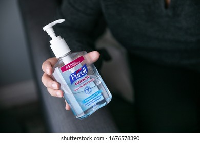 Los Angeles, California / USA - March 18, 2020: A woman putting hand sanitizer on her hands after touching items around the house to avoid getting the coronavirus. Sanitizing hands