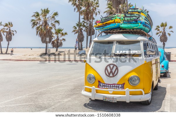 Los Angeles California USA. May 30, 2019. Venice\
beach, Surf boards stacked on a yellow van roof, surf school adv,\
sunny spring day