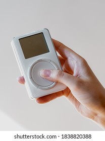 Los Angeles, California / USA - October 20 2020: Female Hand Holding A White Apple IPod First Generation Showcasing Front Screen And Click Wheel 