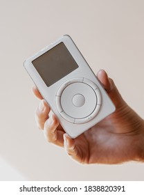 Los Angeles, California / USA - October 20 2020: Female hand holding a white Apple iPod first generation showcasing front screen and click wheel 