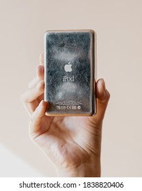 Los Angeles, California / USA - October 20 2020: Female Hand Holding A White Apple IPod First Generation Showcasing The Back Aged And Scratched Mirror With Logo