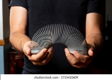 Los Angeles, California/United States - 02/25/2020: A view of a person holding a Slinky toy in the hands.