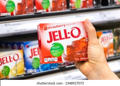 Los Angeles, CA/USA 03/23/2019 shoppers hand holding a box of Jell-o strawberry gelatin dessert at a supermarket aisle