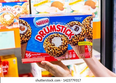 Los Angeles, CA/USA 06/12/2019   Shoppers Hand Holding A Family Size Package Of Nestle Drumstick Sundae Ice Cream Cone In A Supermarket Aisle