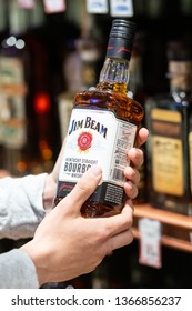 Los Angeles, CA/USA 4/10/2019 Customer hand holding a Bottle of Jim Beam Brand Bourbon whiskey on a liquor store aisle