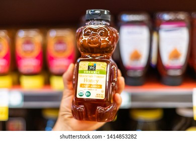 Los Angeles, CA/USA 6/1/2019  Shoppers Hand Holding A Plastic Bear Jar Of 365 Whole Foods Brand Of Organic Light Amber Honey In A Supermarket Aisle
