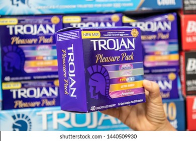 Los Angeles, CA/USA 7-1-2019 Shoppers Hand Holding A Package Of Assorted Trojan Brand Condoms In A Supermarket Aisle