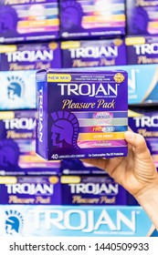 Los Angeles, CA/USA 7-1-2019 Shoppers Hand Holding A Package Of Assorted Trojan Brand Condoms In A Supermarket Aisle