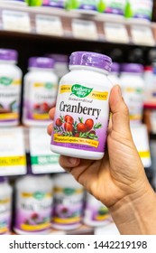 Los Angeles, CA/USA 7-1-2019 Shoppers Hand Holding A Plastic Bottle Of Nature's Way Cranberry Vegetarian Capsules In A Supermarket Aisle