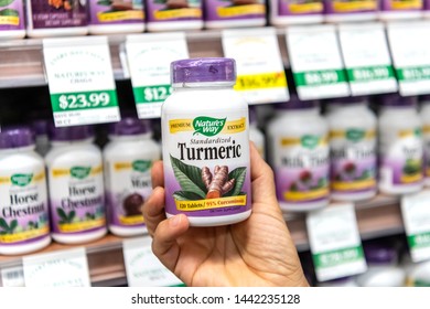 Los Angeles, CA/USA 7-1-2019 Shoppers Hand Holding A Plastic Bottle Of Nature's Way Turmeric Vegetarian Capsules In A Supermarket Aisle